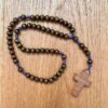 Holz-Rosenkranz mit dunkelbraunen Perlen und Holzkreuz mit der Inschrift "Medjugorje" in einer Gesamtansicht.