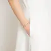 Eine Frau trägt ein Rosenkranz-Armband von Ghirelli - Rosalet mit traditionellen Kreuz in Gold und Silber.