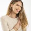 Eine Frau trägt den Rosenkranz Ghirelli mit goldenen und silbernen Perlen an Arm und Hals. Die Goldperlen sind mit Kristallen verziert. Die Frau trägt ein helles Oberteil.