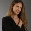 Eine Frau trägt den Rosenkranz Ghirelli mit goldenen und silbernen Perlen an Arm und Hals. Die Goldperlen sind mit Kristallen verziert. Die Frau trägt eine schwarze Bluse.