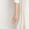 Eine Frau trägt das Rosenkranz-Armband Rosalet in Rosegold und Silber mit Kristallbesatz.