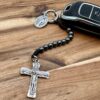 Ein Schlüsselanhänger-Rosenkranz mit 10 Hämatitperlen an einem schwarzen Autoschlüssel - man sieht das Dreifaltigkeitskreuz und auch die wundertätige Medaille