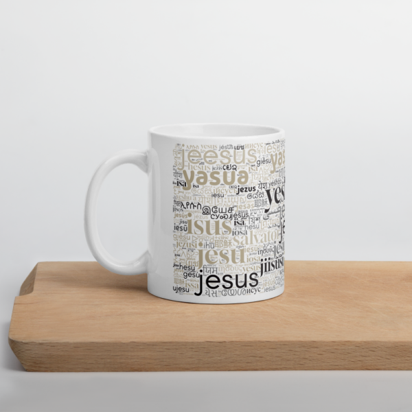 Weiße Tasse mit dem Namen Jesus in allen Sprachen der Welt auf einem Holzbrett - Henkel nach links.