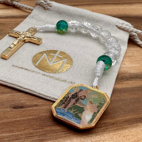 Offener 10er Rosenkranz mit einem goldenen Benediktuskreuz und einer goldenen Medaille von der Taufe Jesu auf einem Stoffbeutel