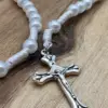 Silbernes Lilienkreuz des Erstkommunion Rosenkranz weiß in Nahaufnahme