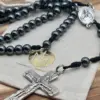 Rosenkranz aus Hämatit mit silbernem Kruzifix auf beigem Stoff-Geschenkbeutel der Rosenkranz Werkstatt