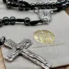 Detailaufnahme des silbernen Kruzifix mit Christusfigur am Hämatit-Rosenkranz Gottes Liebe