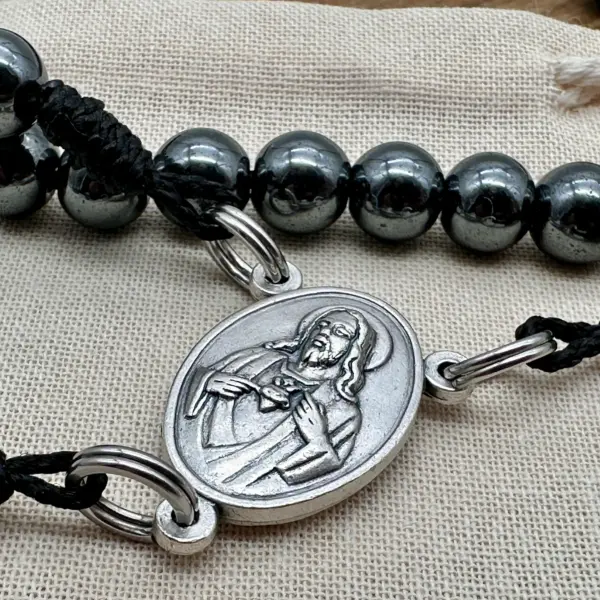 Nahaufnahme des Herz-Jesu-Mittelstücks aus Silber am Hämatit-Rosenkranz Gottes Liebe