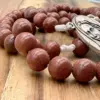 Nahaufnahme der Goldfluss-Perlen mit feinem Goldglimmer am Rosenkranz Medjugorje Goldfluss