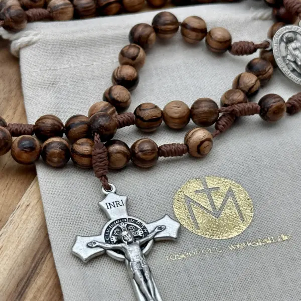 Benediktus-Sternkreuz des Walnussholz-Rosenkranzes auf dem Geschenkbeutel