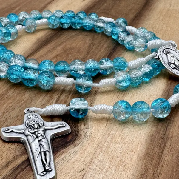 Schönstatt-Kreuz und Crackle-Glasperlen mit Farbverlauf von Türkis zu Klar auf Holz